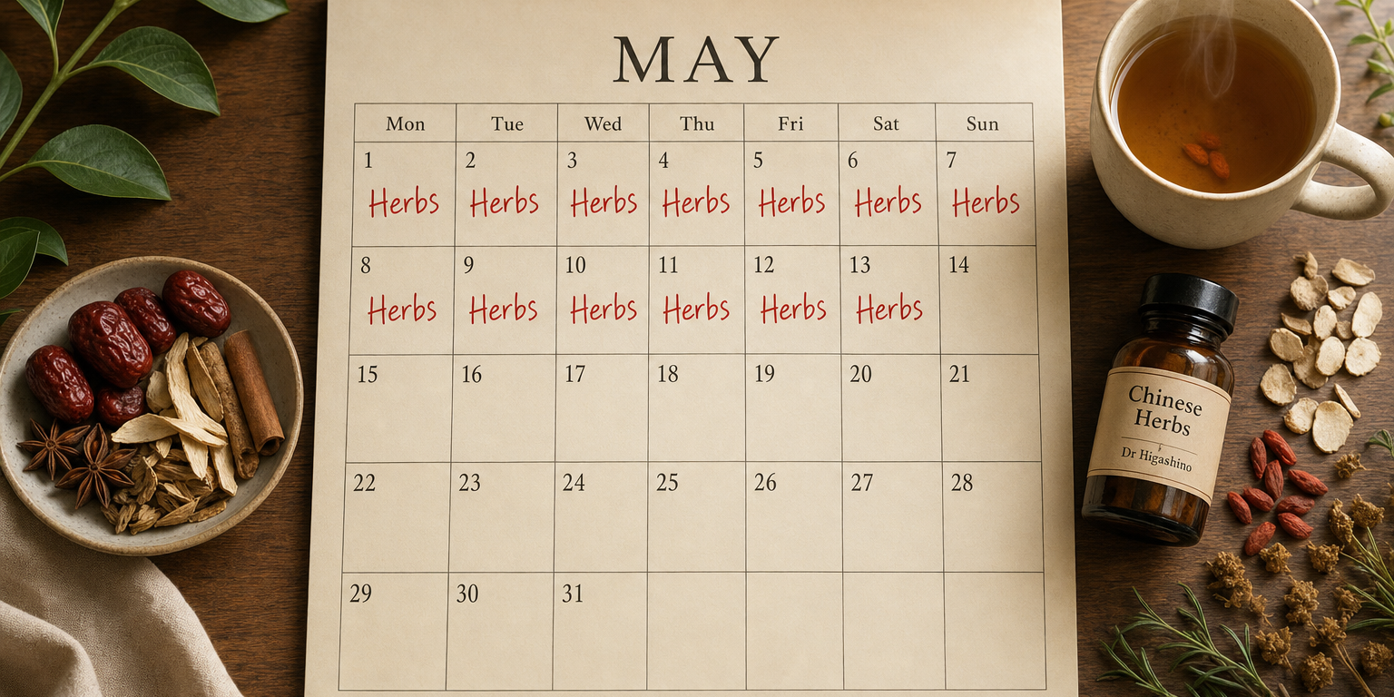 Top-down widescreen flat-lay of a May paper calendar with 'Herbs' written in red on days 1-13, beside a steaming mug of Chinese herbal tea, an apothecary bottle, jujubes and dried roots on warm wood.